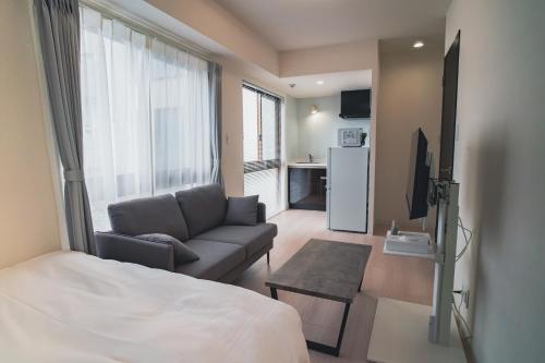 福冈Hotel Star Residence - 無人ホテル的客厅配有床、沙发和电视
