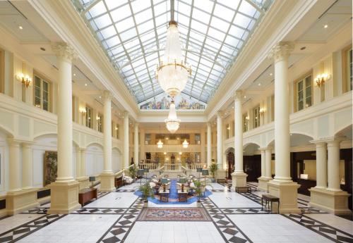 佐世保豪斯登堡阿姆斯特丹酒店的大型大堂设有玻璃天花板和柱子