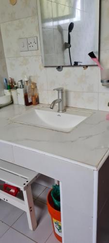 巴加莫约Kaole Cosy Retreat的浴室的柜台设有水槽和镜子
