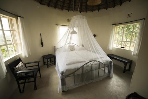 内罗毕尼亚提山别墅的一间卧室配有一张带蚊帐的床