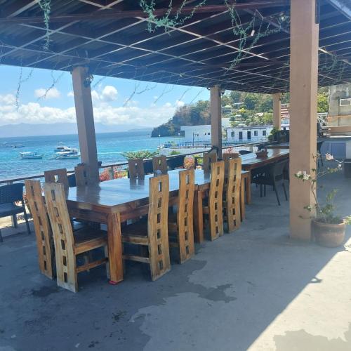 波尔多·格尼拉captngreggs dive resort的一张木桌和椅子,背靠大海