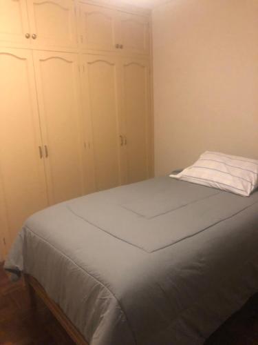 拉巴斯Céntrico apartamento的一间卧室配有一张带白色橱柜的床。