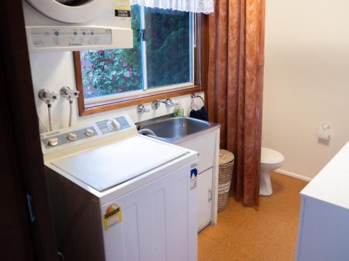 文森提亚Collingwood Beach Cottage - Belle Escapes Jervis Bay的白色的小厨房,配有水槽和窗户