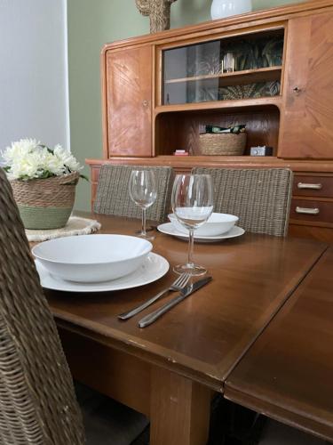 科布伦茨Schängelrooms的一张木桌,上面放有盘子和酒杯