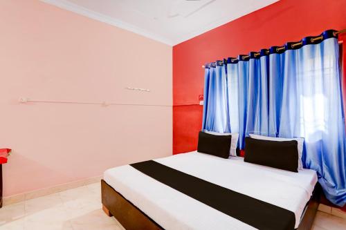比莱OYO Hotel Abhilasha的一间卧室配有蓝色窗帘的床