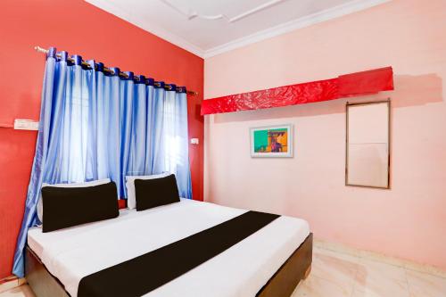 比莱OYO Hotel Abhilasha的一间卧室设有一张红色墙壁和窗户的床