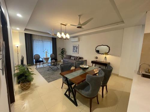 伊斯兰堡1 Bedroom Furnished Apartment at Eighteen Islamabad的用餐室以及带桌椅的起居室。