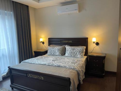 伊斯兰堡1 Bedroom Furnished Apartment at Eighteen Islamabad的一间卧室配有一张带2个床头柜的大床