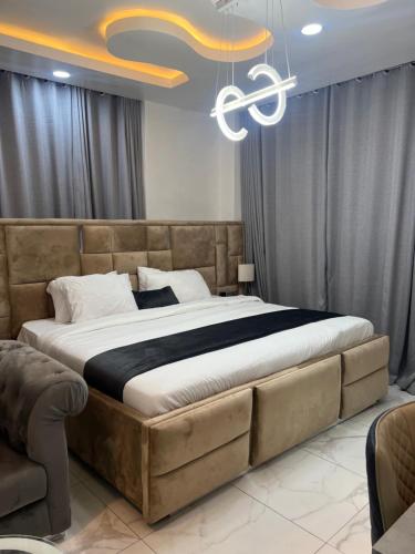 哈科特港HighX Hotels的一间卧室配有一张大床和一个吊灯。