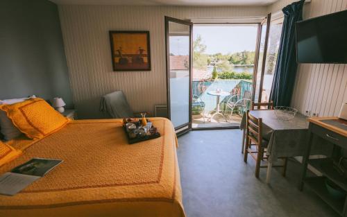 圣保罗莱达莱斯阿加西亚斯酒店的一间卧室配有一张床铺和一张桌子,并设有一个阳台