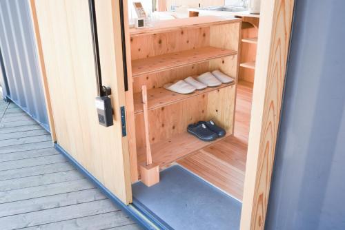 Nishiawakura安全第一客室 Anzen Daiichi INN的通往桑拿浴室的门,里面装有毛巾和鞋子
