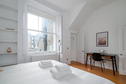 伦敦GuestReady - Chic in the heart of Kensington的白色的卧室设有床、书桌和窗户