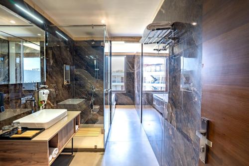 兰纳加Shervani Pebbles And Pines Corbett的一间带水槽和玻璃淋浴的浴室