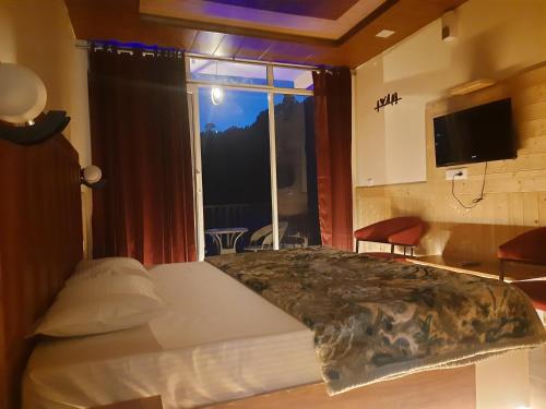 西姆拉Aagaman Woods Homestay的一间卧室设有一张床和一个大窗户