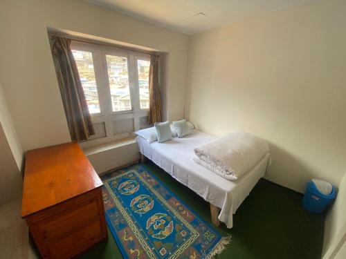 Nāmche BāzārHimalayan Lodge的一间小卧室,配有床和窗户