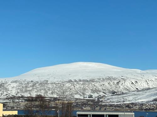 特罗姆瑟Polar Arctic Luxury House - Free parking的雪覆盖的山,与城市