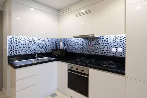 迪拜2 BR Condo in Aykon City Tower - Business Bay的厨房配有白色橱柜和炉灶烤箱。