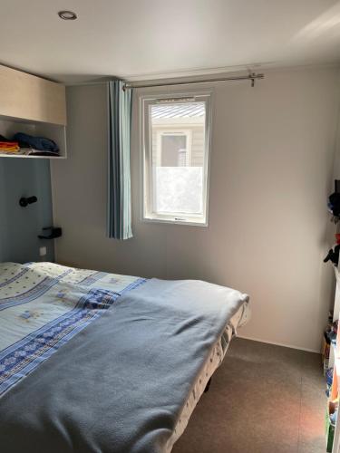 滨海阿热莱斯Mobil home charmant的一间卧室设有一张床和一个窗口