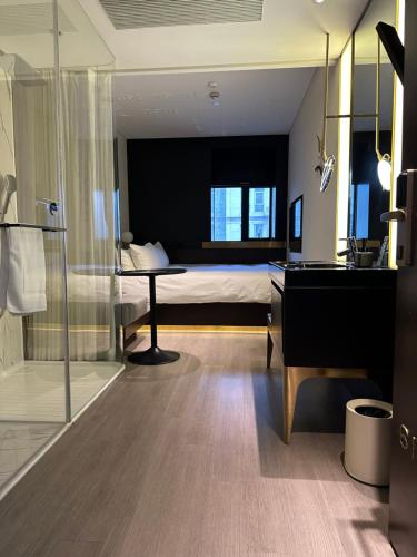 上海上海陆家嘴东方明珠CitiGO欢阁酒店的一间带一张床和一张书桌的卧室以及一间浴室。