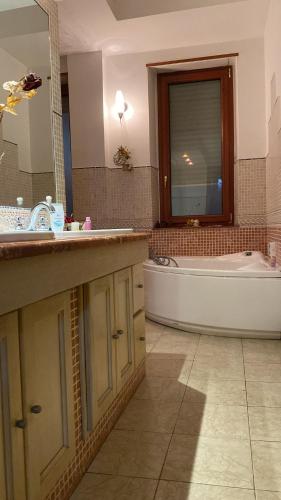 科森扎Luxury Room Cosenza的带浴缸、水槽和浴缸的浴室