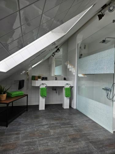 瓦尔肯里德Mittel-Schänke Wieda的浴室提供2条绿色毛巾和镜子