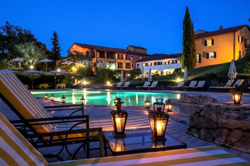 加尔伦达La Meridiana Hotel & Golf Resort的夜间带游泳池的度假村