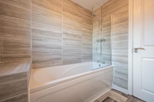 纽波特Atlanta's Residence by Tŷ SA的浴室配有白色浴缸和淋浴。
