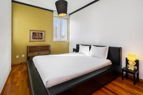 里斯本WHome Cosy Urban Hideaway in Belém with River View的卧室配有一张大白色床和窗户