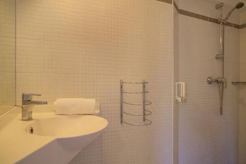 卡尔克富The Originals City, Hotel Novella Confort, Nantes Est的白色的浴室设有水槽和淋浴。