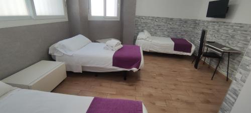 马亚达洪达埃斯科里亚尔旅馆的客房设有两张床、一张书桌和一张书桌