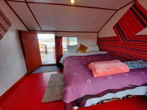 普诺Uros Titicaca UMA lodge的一间小房间的卧室,配有一张床铺