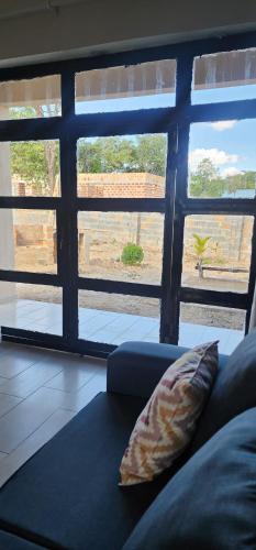 ChanamoAima Villas的客厅设有一张沙发,配有大窗户