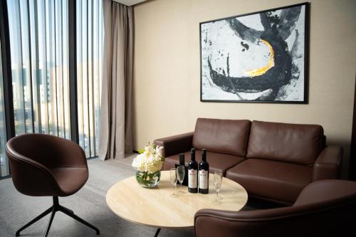 利雅德فندق الما ALMA Hotel的客厅配有沙发和带葡萄酒瓶的桌子