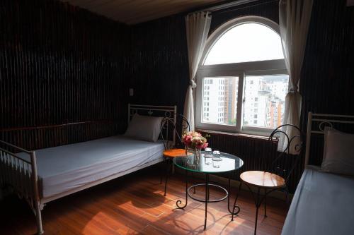 三岛县Chân Mây Tam Đảo的一间卧室配有一张床、一张桌子和一个窗户。