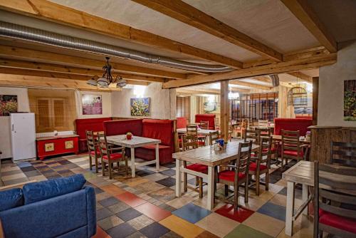 BisztynekFolwark Malinowy Chruśniak的一间带桌椅和红色摊位的餐厅