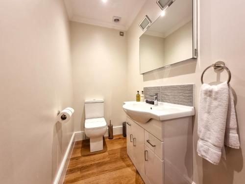 兰迪德诺Min y Don Llandudno的白色的浴室设有水槽和卫生间。