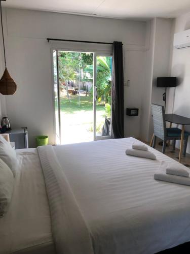 通萨拉Wild Wood x Hansa Beach Fitness Resort的卧室配有一张白色大床和滑动玻璃门
