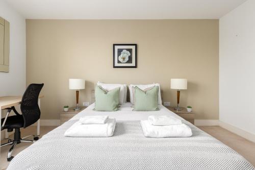 伦敦The Islington Collection的白色卧室配有一张带绿色枕头的大床