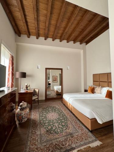 奇维塔卡斯泰拉纳Residenza Palazzo Fortuna - Boutique Hotel的一间卧室配有一张床、一张书桌和一台电视
