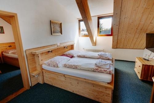 兹蒂尔Penzión Sova Ždiar的一间带两张床铺的卧室,位于带木墙的房间内