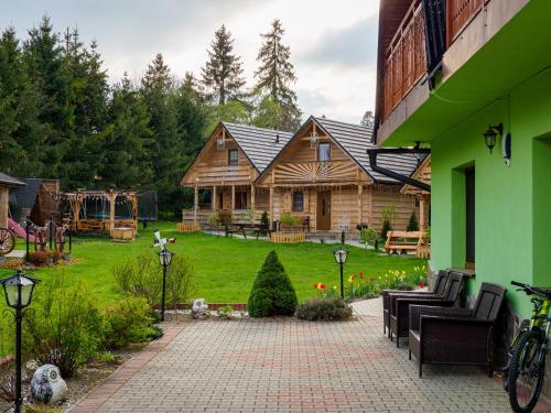乔乔洛Domki i Pokoje obok Term Chochołów U Tadka的小木屋庭院设有椅子和庭院