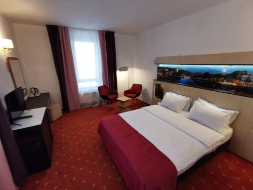 普雷代亚尔Atrium Panoramic Hotel & Spa的酒店客房设有一张大床和一张书桌。