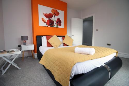 巴里Stunning sea views - Barry's Retreat by Tŷ SA的一间卧室配有一张带橙色墙壁的大床