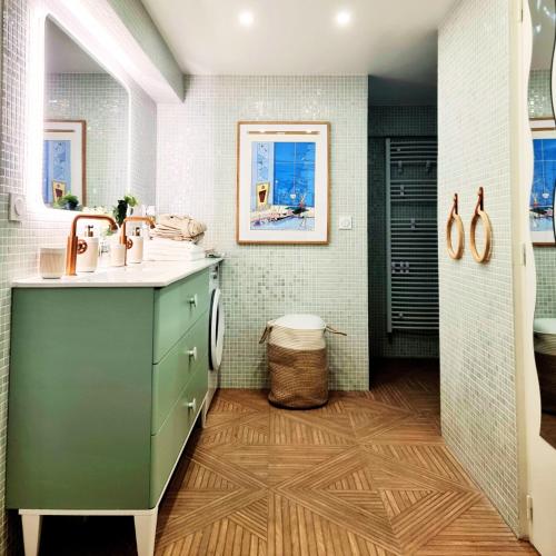 克劳德LA CAMPAGNE à PARIS的一间带绿色橱柜和水槽的浴室
