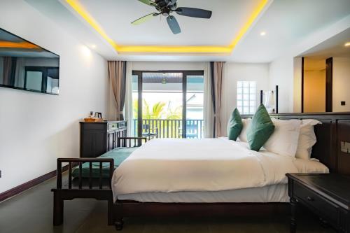 琅勃拉邦Manyo Hotel and Resort的一间卧室配有一张大床和吊扇