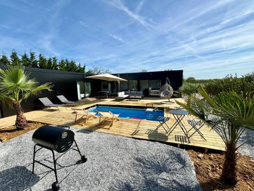奥登河畔的布雷特维尔Evasion tropicale的一个带游泳池和房子的后院