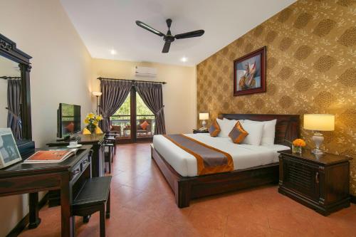 美奈Sea Lion Beach Resort Mui Ne的酒店客房配有一张床、一张书桌和一张四柱床