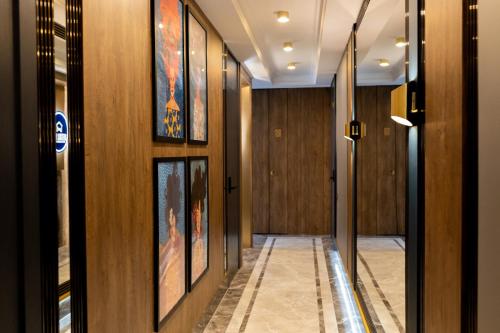 希奥利艾Four Sisters Luxury Rooms in Siauliai的走廊设有木镶板和墙上的绘画作品