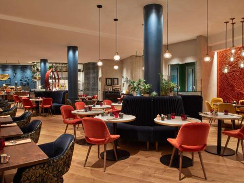 布鲁塞尔布鲁塞尔欧洲索菲特酒店的一间带桌椅的用餐室和一间餐厅