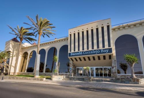 科拉雷侯科拉莱霍湾巴瑟罗度假酒店-仅限成人的一座棕榈树购物中心,位于一座建筑前